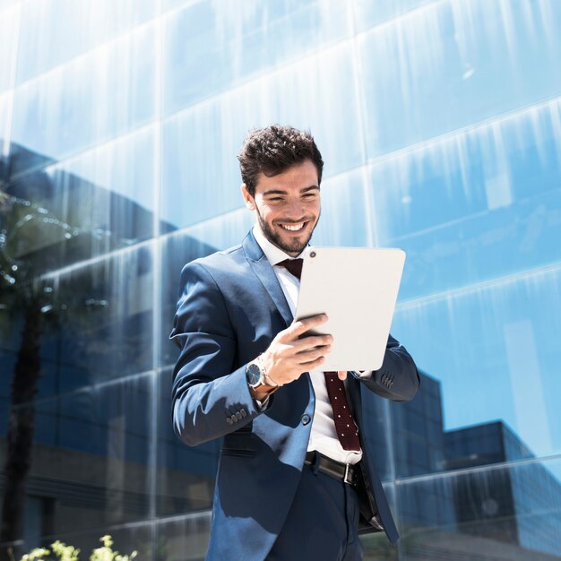 Free Photo side view smiley man looking at tablet