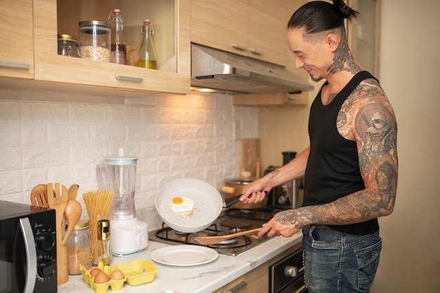 Side view smiley man making omelette