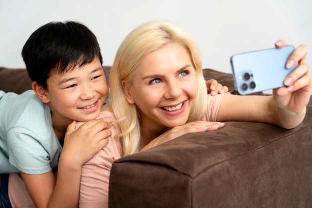 Side view smiley mother and kid on couch