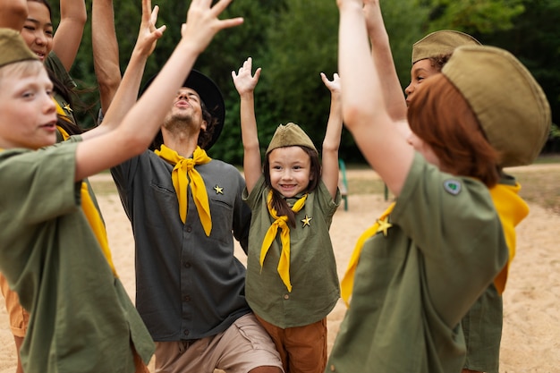 Free photo side view smiley scouts outdoors