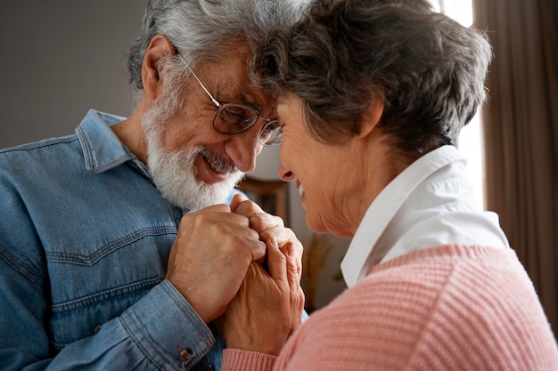 Side view smiley senior couple holding hands