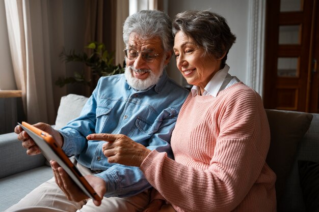 Side view smiley senior people with tablet