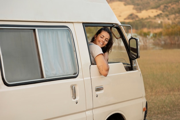 Free photo side view smiley woman in campervan