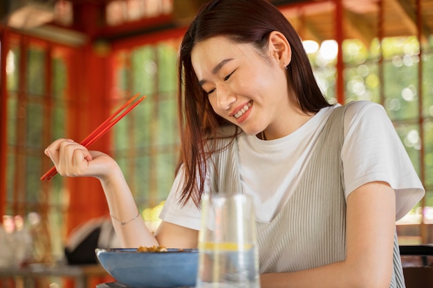 Side view smiley woman holding chopsticks