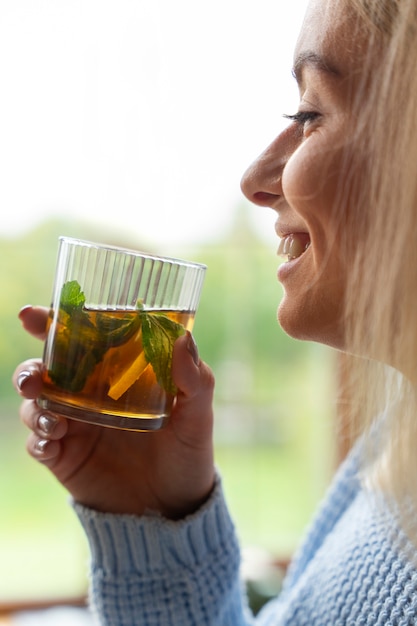 Free Photo side view smiley woman holding drink