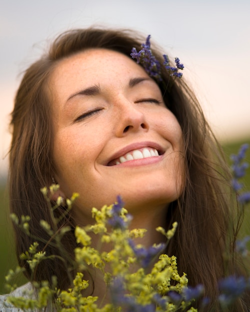 Side view smiley woman holding flowers