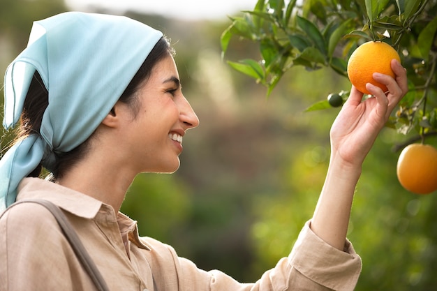 Free photo side view smiley woman holding fruit