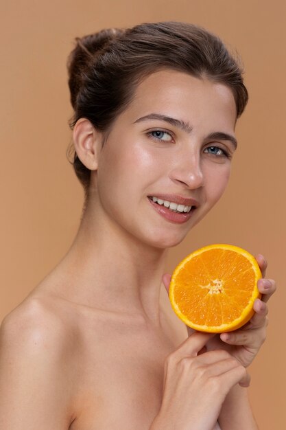 Side view smiley woman holding orange