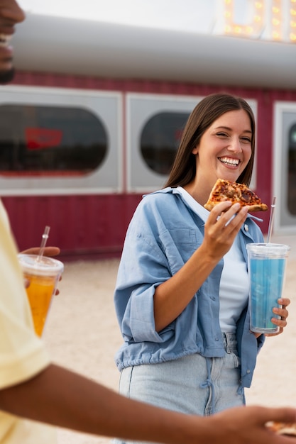 Free photo side view smiley woman holding pizza