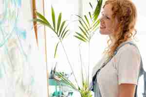 Free photo side view smiley woman looking at a wall