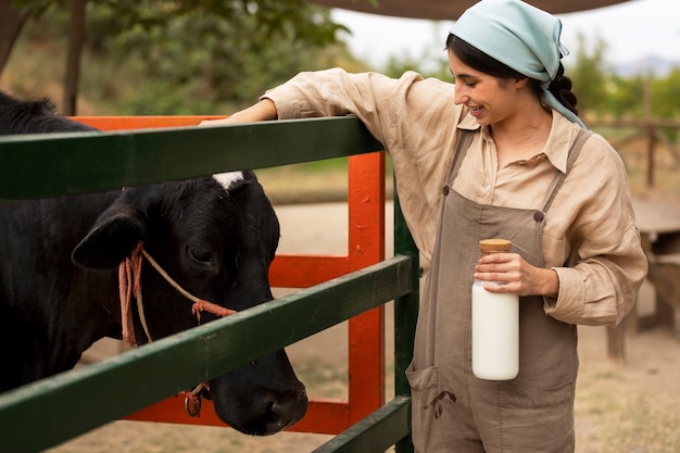 Side view smiley woman petting cow