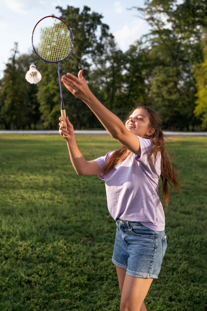 Side view smiley woman playing badminton