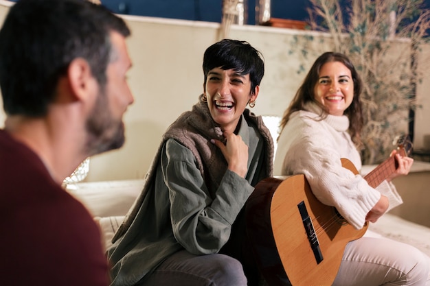 Free photo side view smiley woman playing the guitar