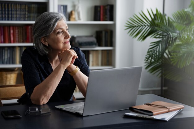 Side view smiley woman with laptop