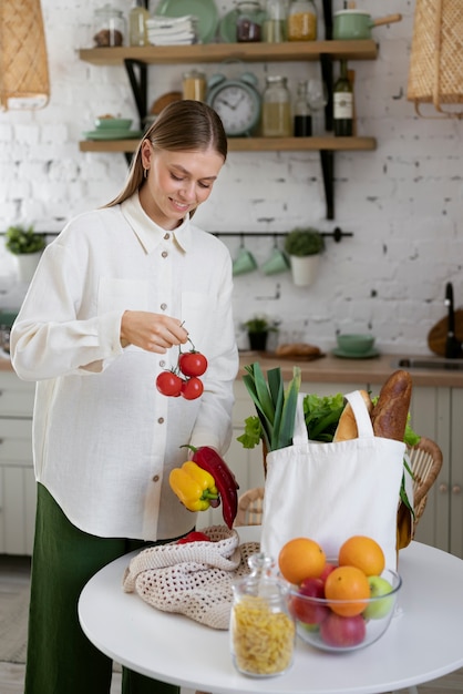 Free Photo side view smiley woman with tomatoes