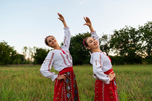 Free photo side view smiley women dancing outdoors