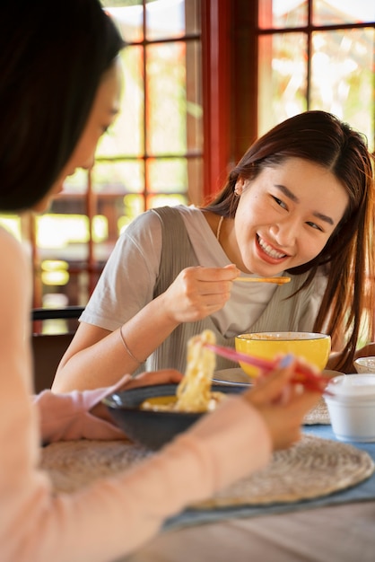 Free photo side view smiley women with delicious food