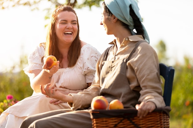 Free photo side view smiley women with fruits