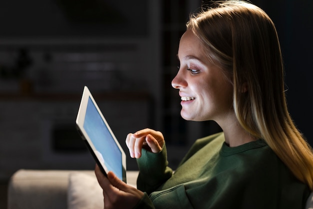 Free photo side view of smiling woman with tablet