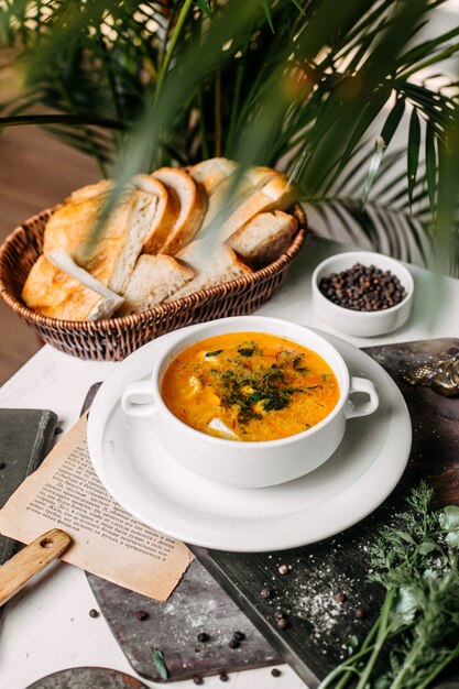 Side view of soup with cauliflower and potatoes in a white bowl