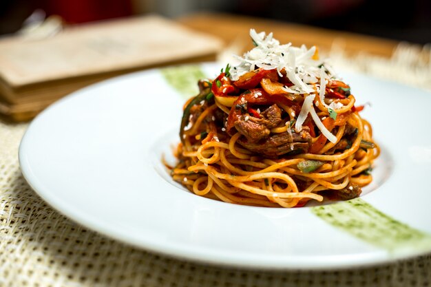 Side view spaghetti with meat and grated cheese