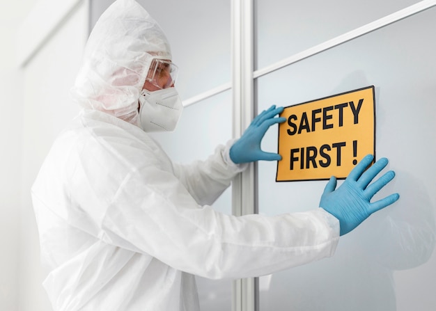 Free photo side view specialist holding safety first sign