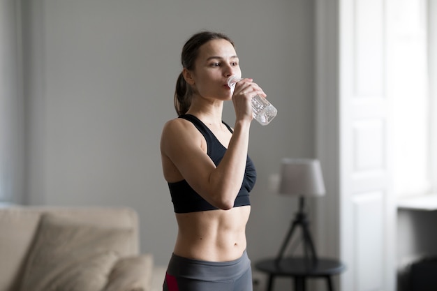 Side view of sporty woman drinking water