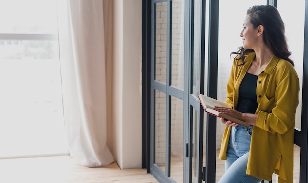 Side view standing woman with book