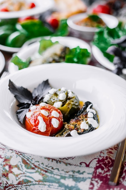 Free Photo side view of stuffed vegetables with meat and cream sauce in a white plate