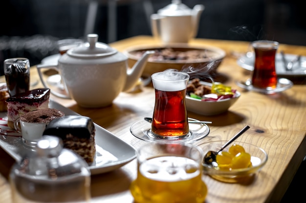 Side view sweet tea table with a glass of armudu of tea