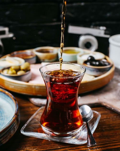 Side view of tea pouring into armudu glass