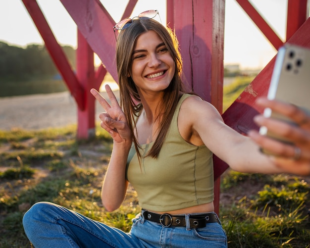 Free Photo side view teen holding smartphone