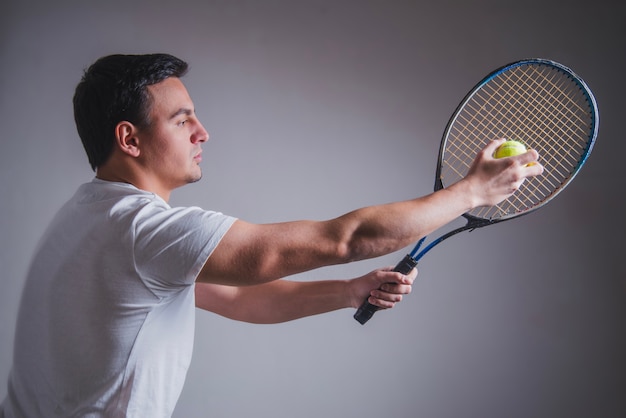 Free Photo side view of tennis player posing with racket and ball