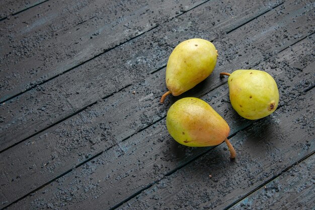 Side view three pears three green pears are laid out in a circle on grey background