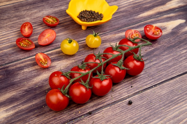 Side view of tomatoes with black pepper seeds on wooden table