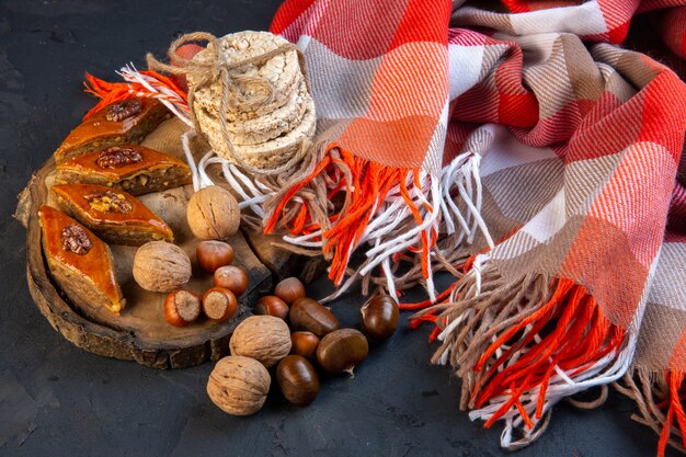 Side view of traditional azerbaijani baklava with whole nuts and rice breads on plaid with tassel