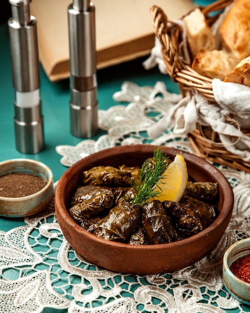 Side view of traditional dolma in grape leaves in clay bowl