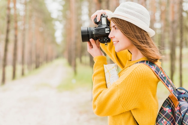 Free photo side view of traveler taking a photo