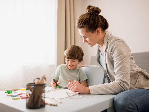 Side view of tutor teaching child at home