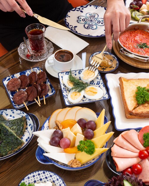 Side view of various plates of food fo breakfast as fried eggs toasts tea with sweetness