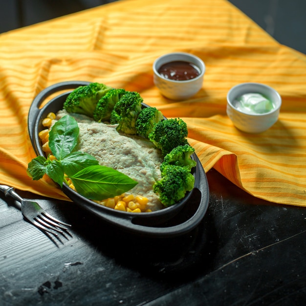 Free Photo side view of vegetable salad with corns and broccoli served with sauce on the table