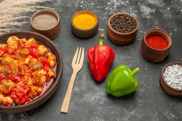 Free photo side view of vegetable spicy chicken soup in a brown pot knife and different spices