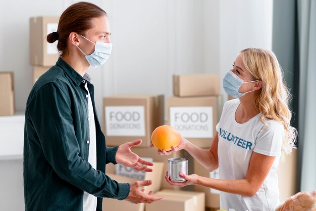 Side view volunteer giving out food as donation