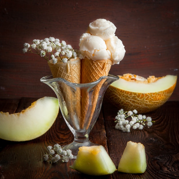 Free photo side view waffle cones with melon slices and ice cream and gypsophila in ice cream cup