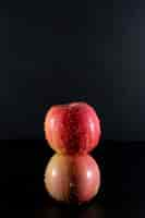 Free photo side view wet red apples on blac¡k