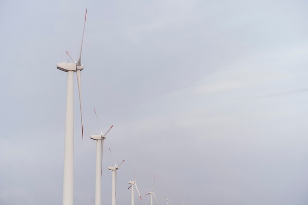 Side view of wind turbines generating electricity with copy space