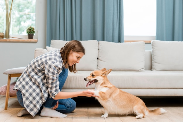 Side view of woman asking for her dog's paw