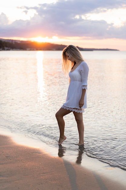 Side view of woman on beach at sunset