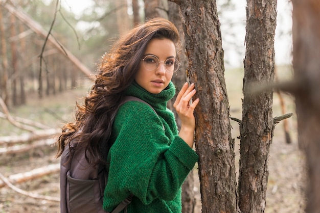 Free photo side view woman beside trees