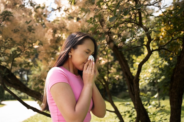 Free Photo side view woman blowing her nose